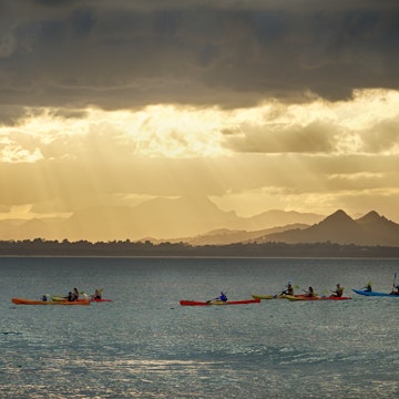 Kayakers watch for whales as the sun sets