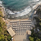 Birds'-eye view of a small beach covered with umbrellas
