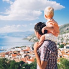 Father and son look at a view over the Croatian coast near Split