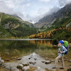 Young hiker in colorful fantastic mountain landscape at gold autumn near Popradske Pleso lake in High Tatras