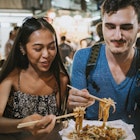 Young couple having dinner together at the night market