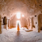 A young girl walking inside a cave church in the Zelve Ancient City at Cappadocia in Nevsehir, Turkey