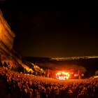 Crowd watches band play with a scenic view of the surroundings.