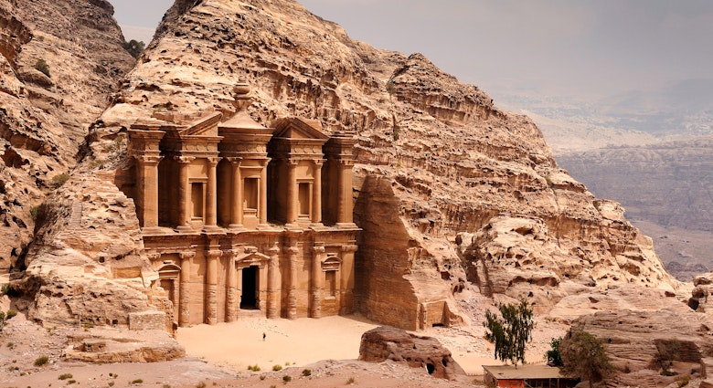 Person stands near the doorway to the Monastery (Ad Deir) in Petra.
972766398
Spirituality, Scenics - Nature, UNESCO World Heritage Site, Architecture, Famous Place, International Landmark, Looking At View, Extreme Terrain, UNESCO, Monument, National Landmark, Petra - Jordan, Stone Material, Tourist, Ma'an Governorate, Building Exterior, Tomb, Archaeology, Sand, Desert, No People, Middle East, Jordan - Middle East, Mountain, Hiding, Middle Eastern Culture, Ancient Civilization, Facade, Monastery, Carving - Craft Product, Large, Travel Destinations, Horizontal, Wadi Musa, Temple - Building, Landscape - Scenery, Red, Al Deir Temple, Cultures, Color Image, Stone - Object, History, Sandstone, Indigenous Culture, Jordan, Ancient, Old, Adventure, Rock - Object, Photography, Built Structure, The Past, Sky, Nature