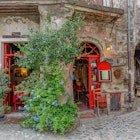 Calcata, Lazio, Italy - September 9, 2017: Small local two-door red with a vine between the two doors, License Type: media, Download Time: 2024-10-10T20:09:37.000Z, User: tasminwaby56, Editorial: true, purchase_order: 65050, job: Online Editorial, client: Rome day trips, other: Tasmin Waby