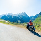 One person riding bike on Ha Giang motorbike loop, famous travel destination bikers easy riders. Ha Giang karst geopark mountain landscape in North Vietnam. Winding road in stunning scenery.   License Type: media  Download Time: 2022-05-04T03:08:59.000Z  User:   Is Editorial: No  purchase_order:
