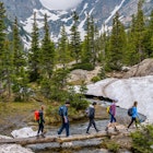 Estes Park, Colorado, USA - June 24, 2017: On a foggy spring day, a group of hikers walking cross a tree trunk bridge over Tyndall Creek on Emerald Lake Trail at base of Hallett Peak and Flattop Mtn.
708951949
